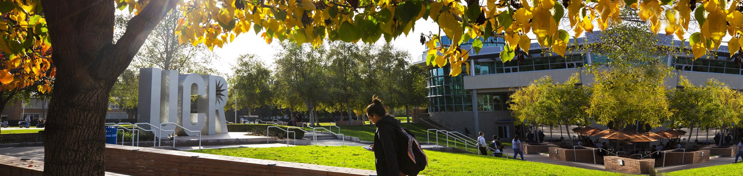 Woman walking before UCR sculpture